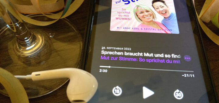 Smartphone mit Kopfhörern und Podcast-Player "Mut zur Stimme"